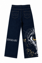 Dark blue denim jeans shown from the back, featuring 'SINSKARI' printed in white on the left leg and a large white and gold eye graphic with gold paint splatters on the right leg.