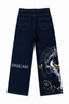 Dark blue denim jeans shown from the back, featuring 'SINSKARI' printed in white on the left leg and a large white and gold eye graphic with gold paint splatters on the right leg.